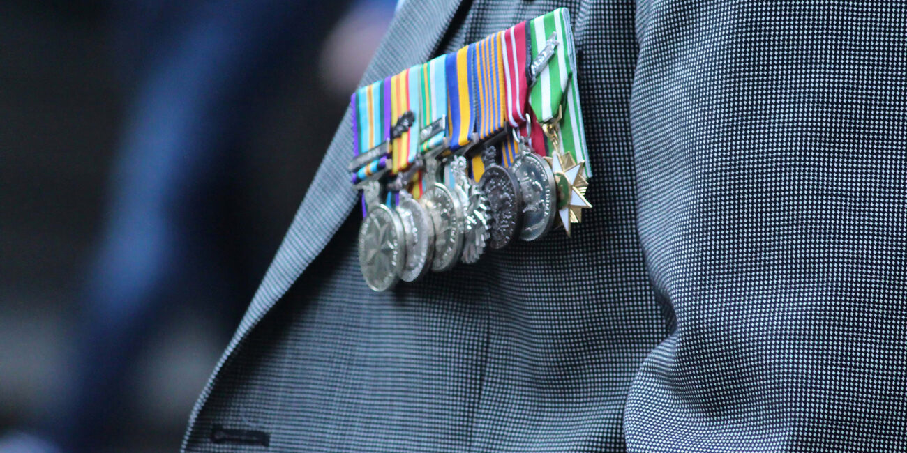 An Anzac Day representative wearing medals in a grey suit